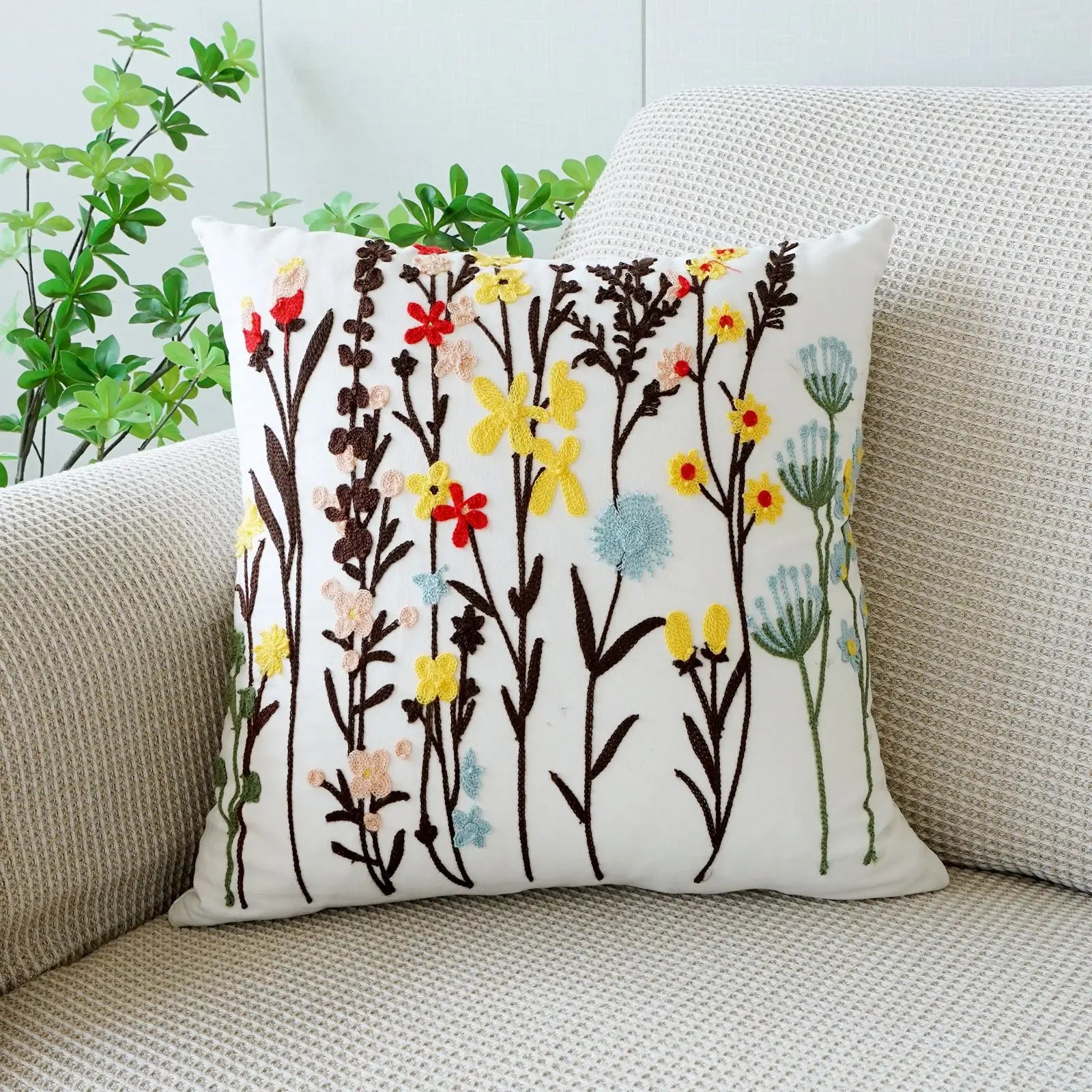 Decorative pillow with floral pattern on a beige couch. Floral embroidered throw pillow cover boho decor