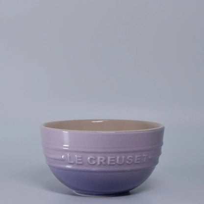 Purple ceramic bowl with 'LE CREUSET' branding on a gray background Gradient ceramic rice bowl in bright colors, bone china soup and noodle bowl, dessert and pudding kitchen tableware for boho home dining