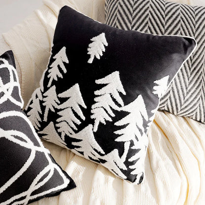 Black and white patterned pillows on a beige surface. Boho Holiday decor
