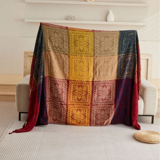 Colorful patterned bohemian blanket draped over a chair in a room with a light background
