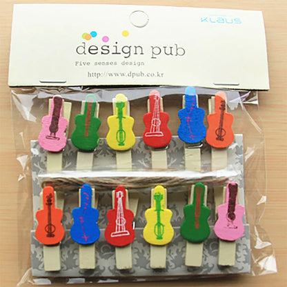 Colorful guitar-shaped paper clips in a clear package with 'design pub' branding.