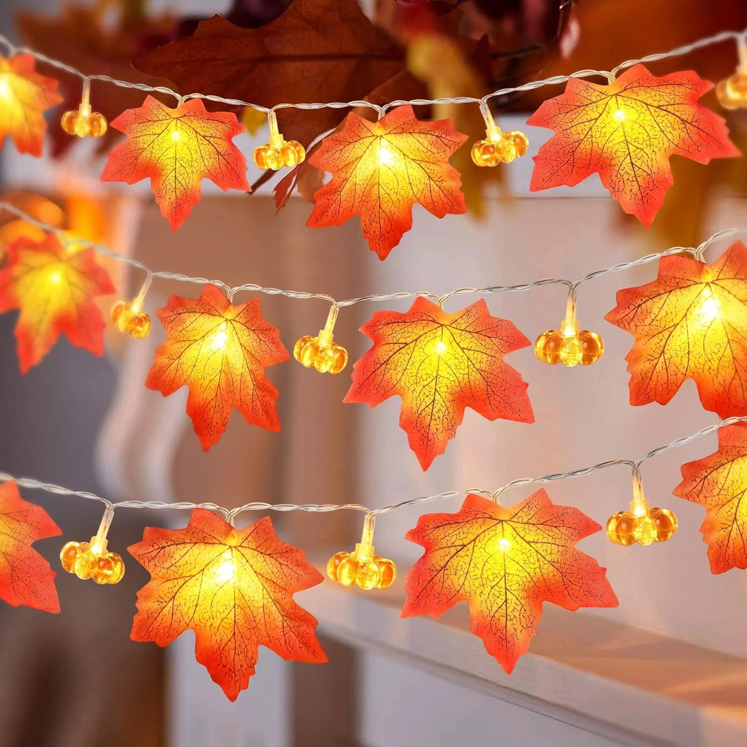 String lights with red and orange leaf decorations on a blurred background. fall leaf lights 