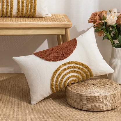 Decorative pillow with brown and gold patterns on a woven stool and bench. Nordic blue tufted cushion cover with geometric stripe and grid crochet pattern, tassel pillow cover for sofa, bed, and boho home decor