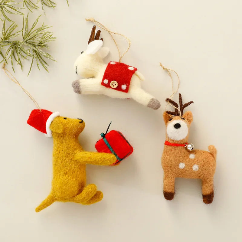 Three festive felt wool ornaments shaped like a dog, deer, and reindeer on a light background.