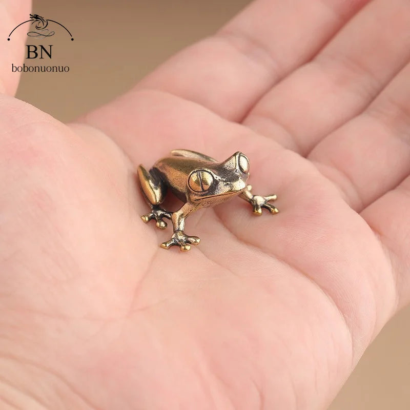 Small bronze frog figurine held in a hand with brand 'bobonuono' visible.