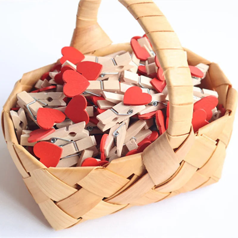 Basket filled with wooden clothespins, some with red heart shapes, on a white background