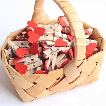 Basket filled with wooden clothespins, some with red heart shapes, on a white background