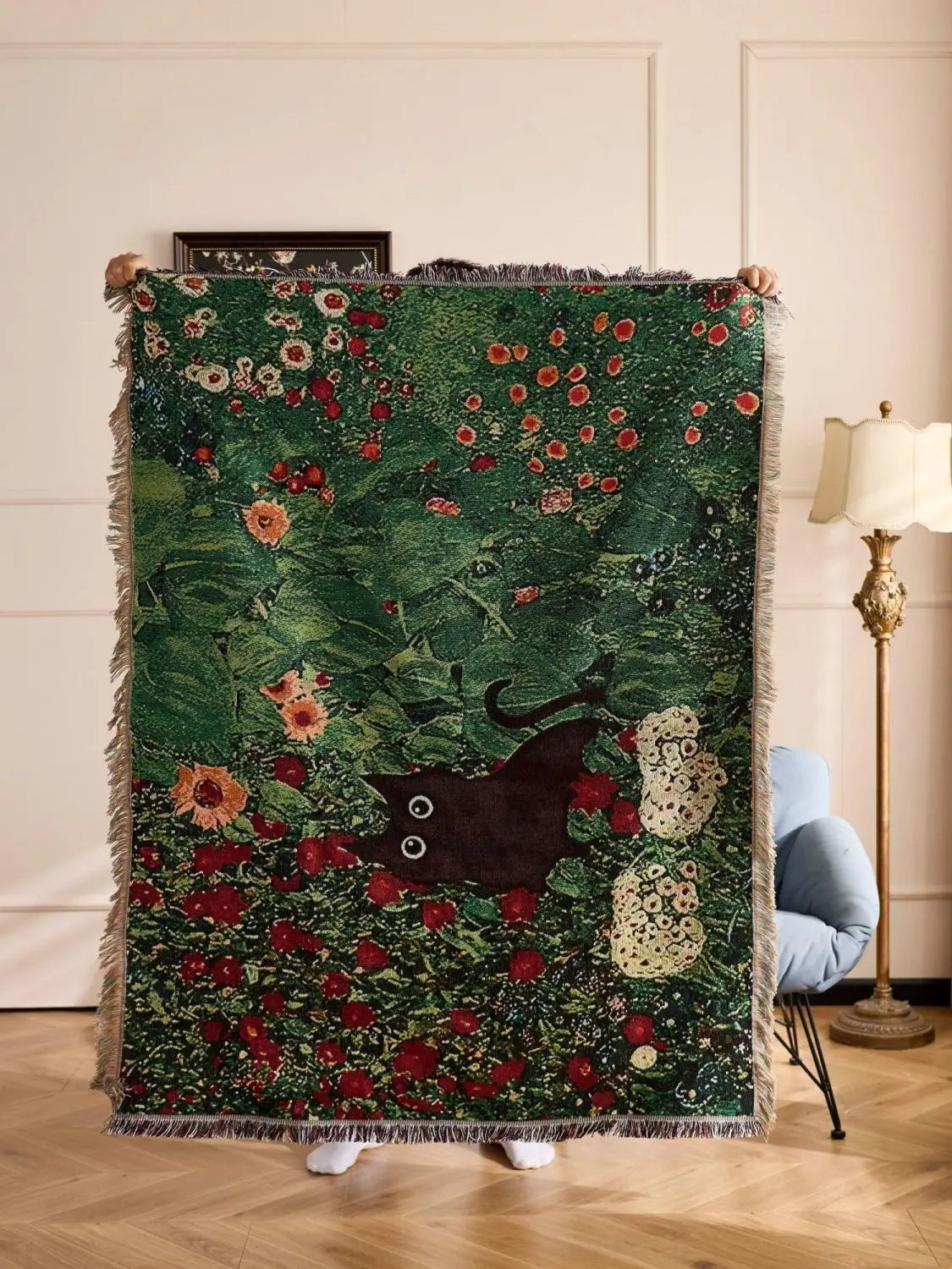 Decorative blanket with floral and animal pattern draped over a chair in a room. Cat woven throw blanket for boho sofa and home decor