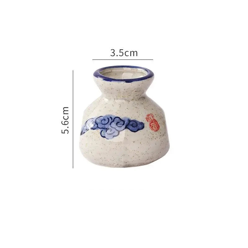 Small ceramic vase with blue and red design on a white background