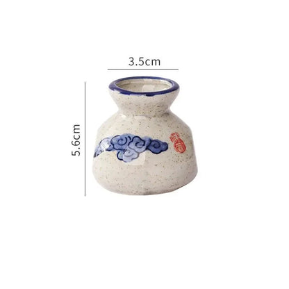 Small ceramic vase with blue and red design on a white background