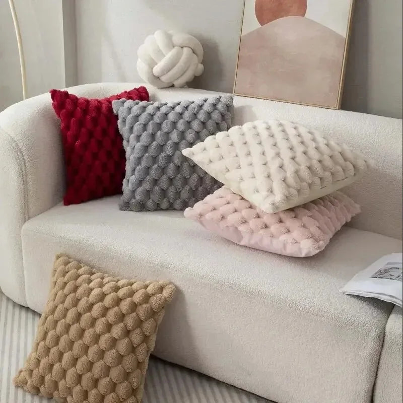 Decorative pillows on a beige sofa with a neutral background