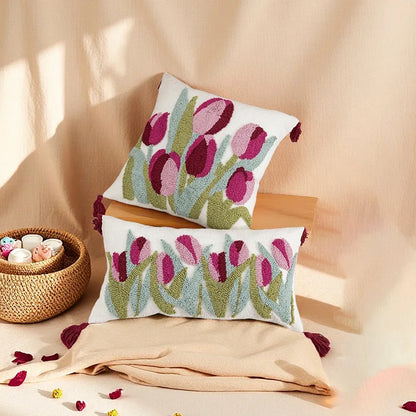 Floral patterned pillows on a beige surface with a woven basket and decorative items.