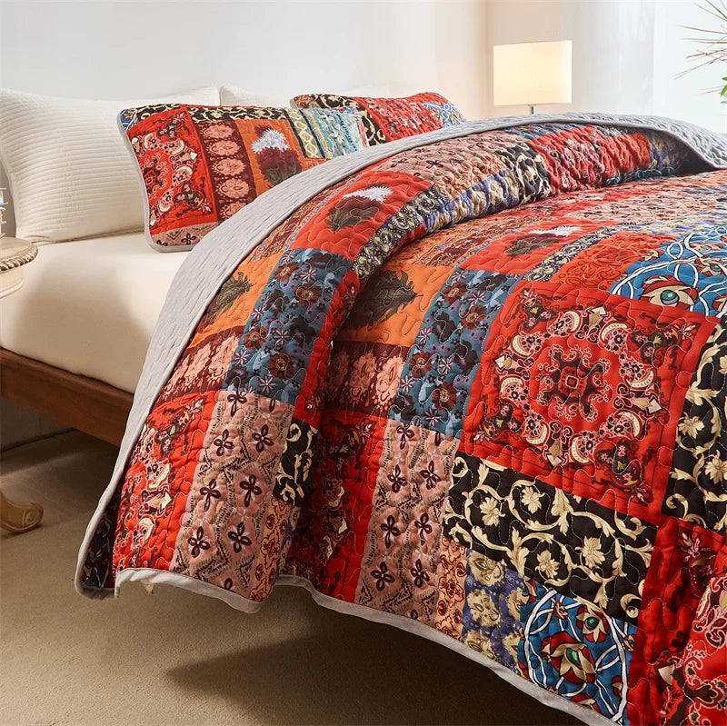 Colorful patchwork quilt on a bed with pillows in a bedroom setting. Lightweight boho quilted bedspread set with pillow shams, soft all-season coverlet for queen, king, full, or twin beds in modern cloud pattern design.