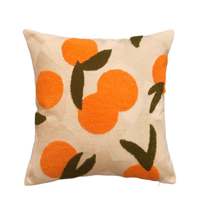 Decorative pillow with orange and green pattern on a beige background