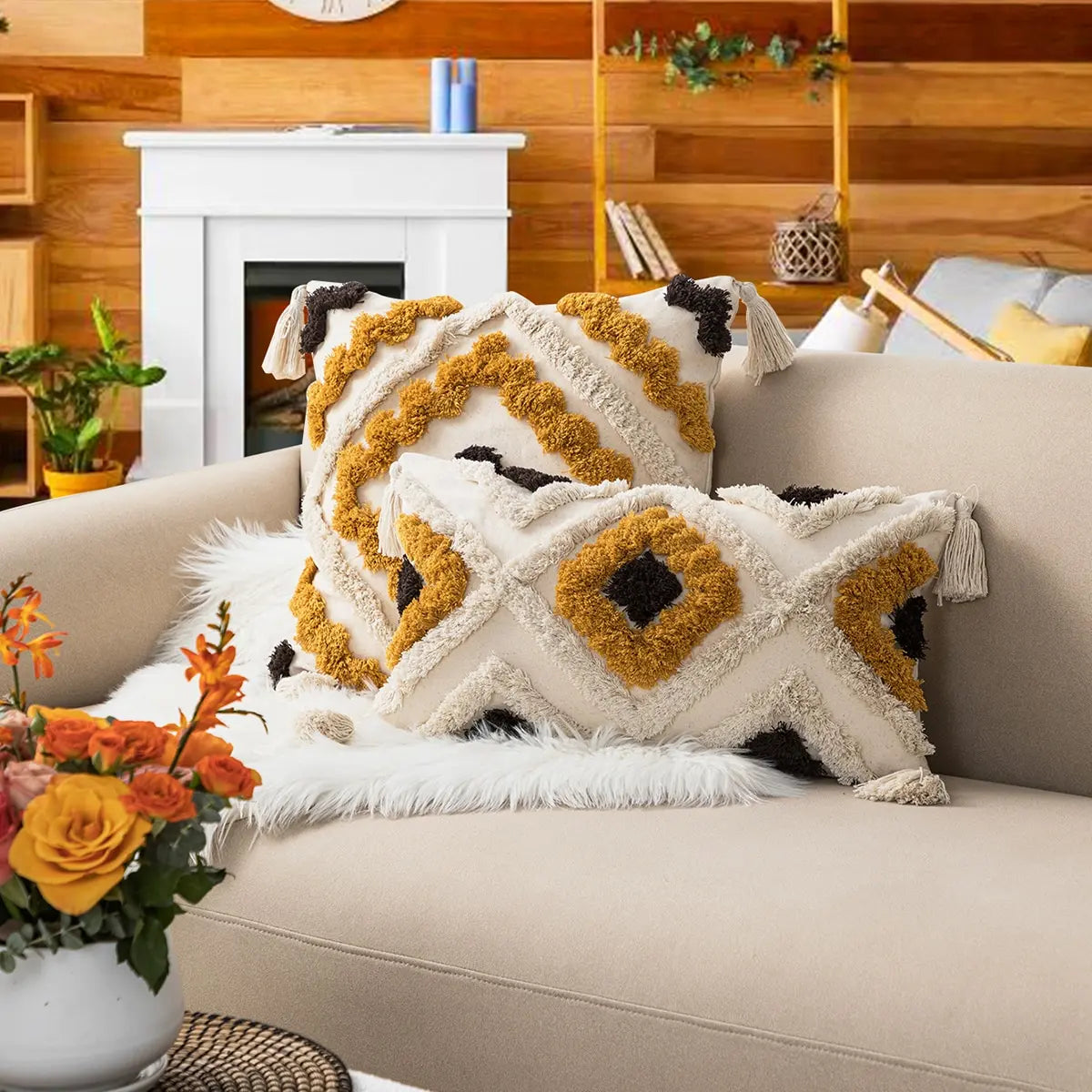Decorative pillows on a couch with a fireplace and wooden wall in the background
