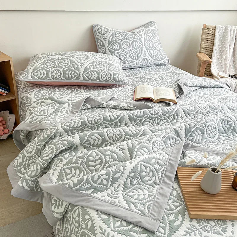 Bed with gray patterned bedding and pillows in a bedroom setting. Boho breathable lightweight summer spring fall blanket quilt bedspread 
