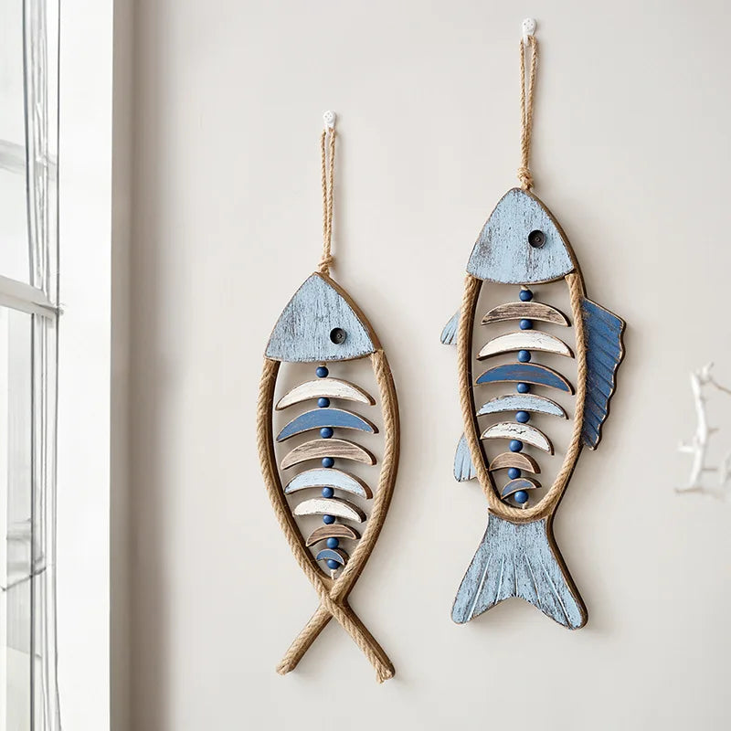 Two fish-shaped wall decorations with wooden and rope details on a light background boho home decor, coastal home accents, nautical wall hanging, wooden fish wall decor, Mediterranean decor, beach house decoration, rustic fish ornament, vintage boho living room decor, seaside wall art, summer housewarming gift