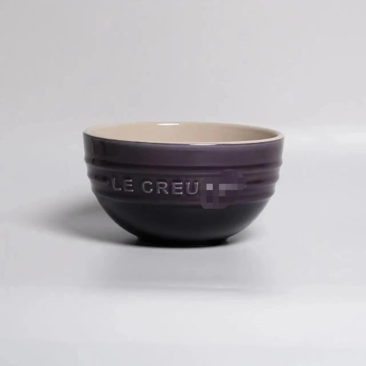 Purple ceramic bowl with 'LE CREUSET' branding on a gray background Gradient ceramic rice bowl in bright colors, bone china soup and noodle bowl, dessert and pudding kitchen tableware for boho home dining