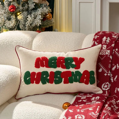 Decorative pillow with 'Merry Christmas' text on a couch with a Christmas tree in the background