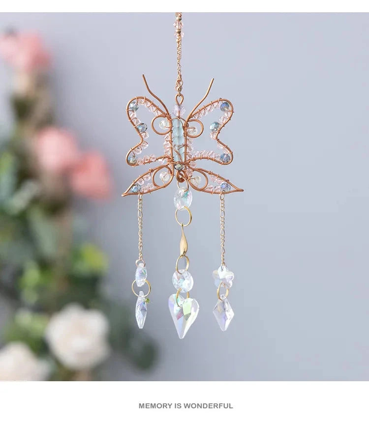 Butterfly-shaped decorative hanging with crystal-like elements on a blurred floral background boho home decor, crystal wind chime, sun catcher for windows, moon prism chime, agate stone hanging, garden art decor, patio hanging decoration, boho housewarming gift, spiritual gift, crystal suncatcher, balcony decor, meditation decor, handmade crystal chime