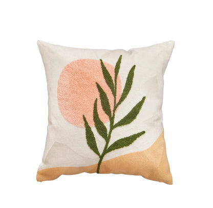 Decorative pillow with pink circle and green leaves on a white background