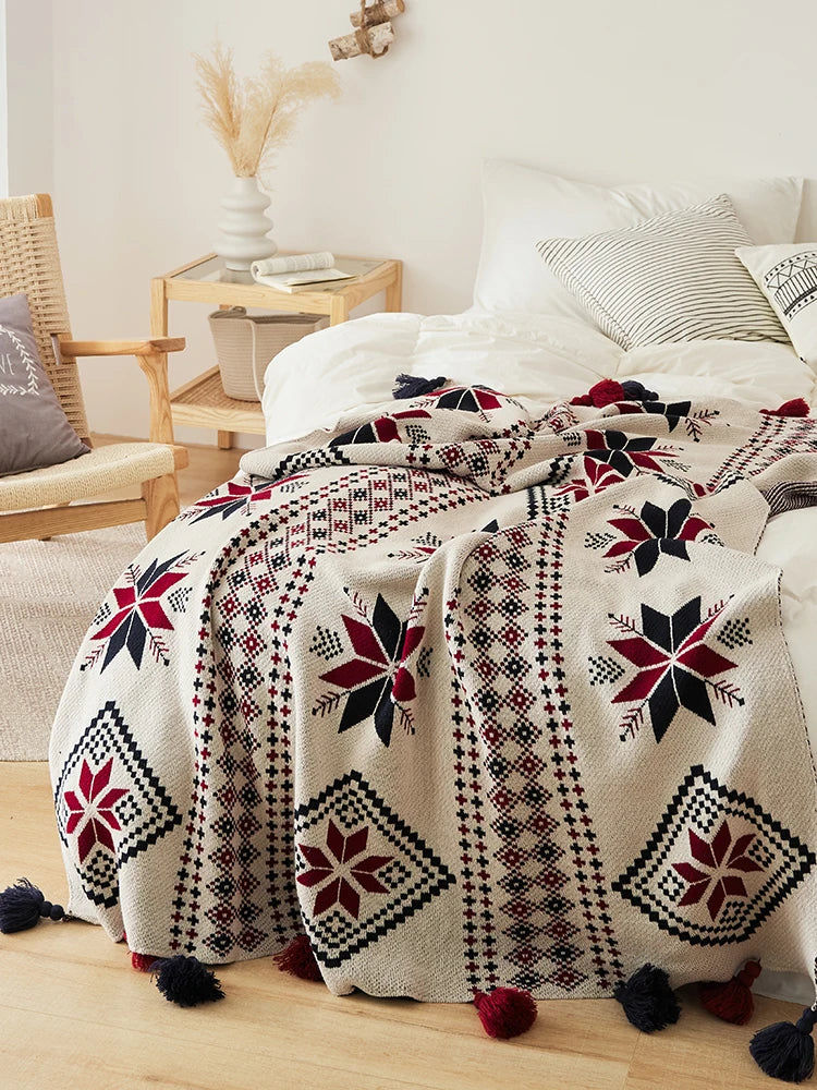 Decorative boho Christmas blanket with geometric pattern on a bed in a bedroom setting