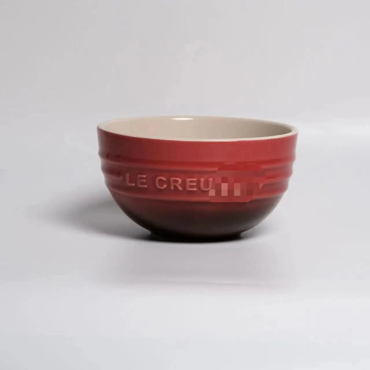 Red mixing bowl with 'Le Creuset' branding on a light gray background Gradient ceramic rice bowl in bright colors, bone china soup and noodle bowl, dessert and pudding kitchen tableware for boho home dining