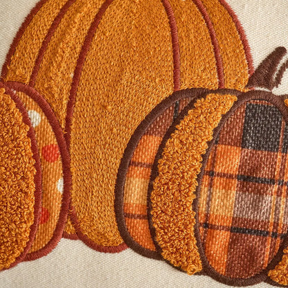 Embroidered patch of pumpkins with textured details on a fabric background. Festive autumn pumpkin cushion case for sofa or bed