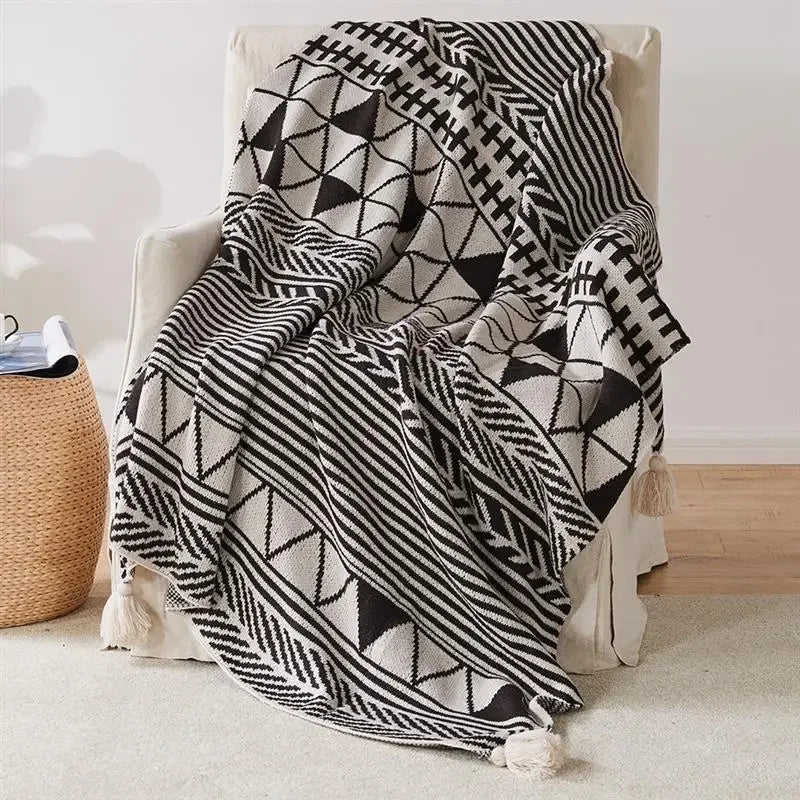 Bohemian Black and white patterned blanket draped over a chair in a room.