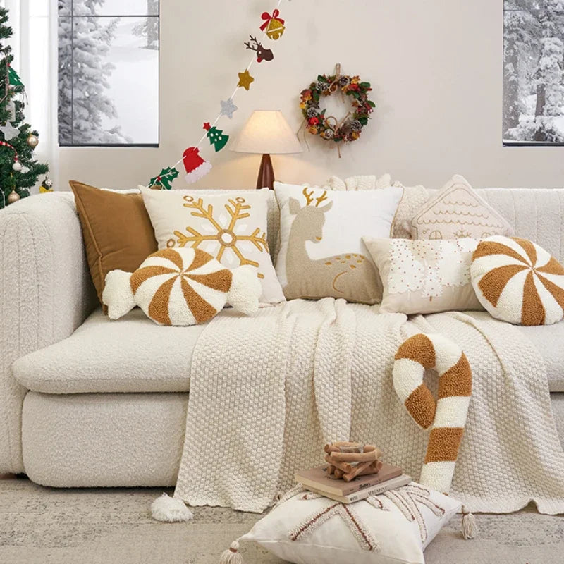Cozy living room with a decorated Christmas tree, wreath, and festive pillows on a sofa.