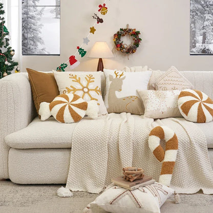 Cozy living room with a decorated Christmas tree, wreath, and festive pillows on a sofa.