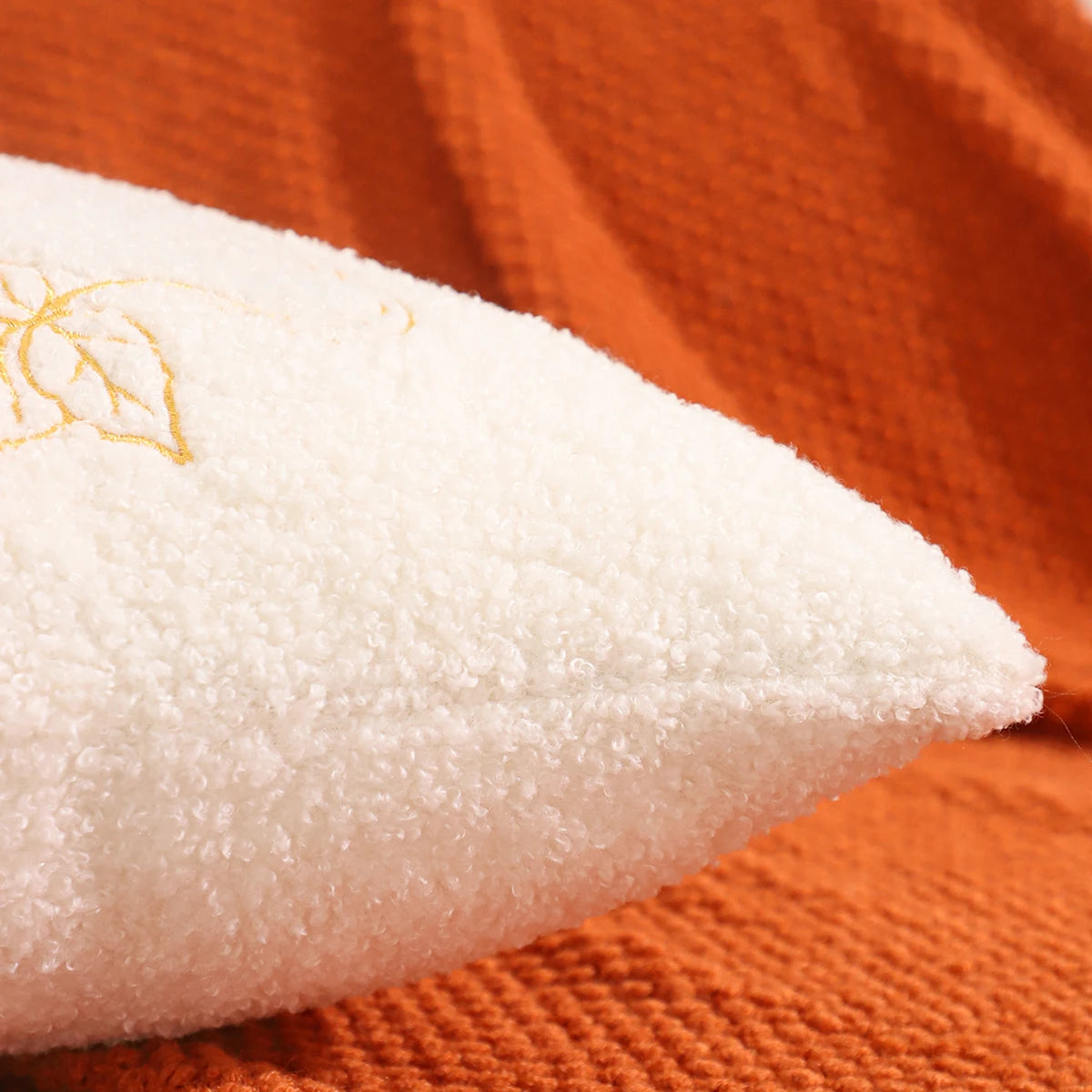 Close-up of white fabric with gold embroidery on an orange background. fall boho pillow throw gift ideas
