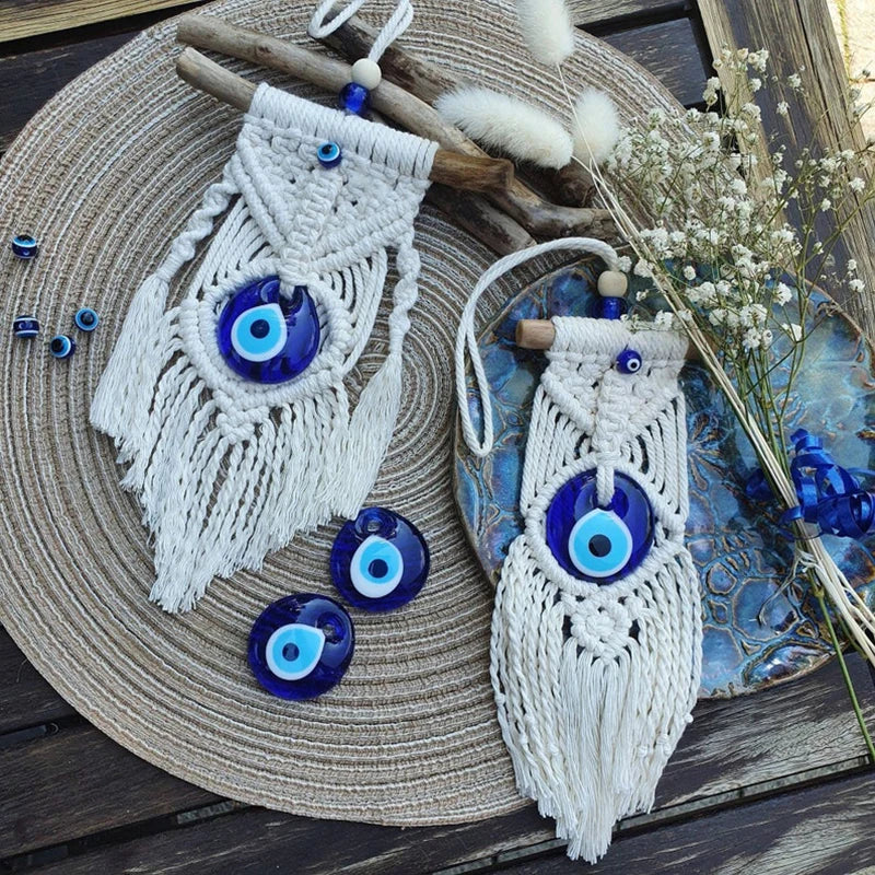Macrame wall hangings with blue evil eye beads on a textured surface.