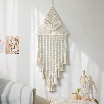 Macrame wall hanging on a white wall with a bed and plant in the background boho home decor, macrame wall hanging, triangle dream catcher, woven tapestry, handmade cotton wall decor, tassel wall hanging, bedroom door decor, housewarming gift, rustic bohemian art, boho apartment wall decor, neutral textile art