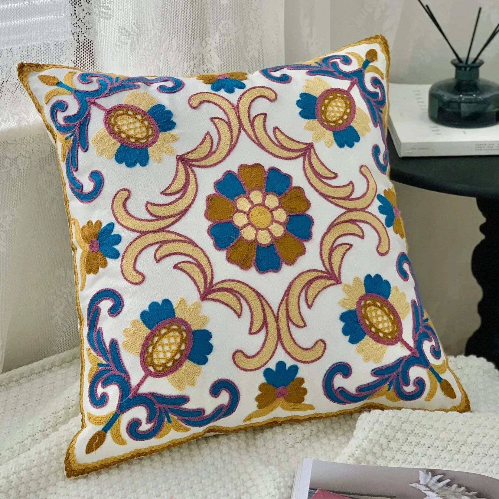 Decorative pillow with floral pattern on a couch, Handcrafted embroidered cushion cover on armchair – modern boho living room decor