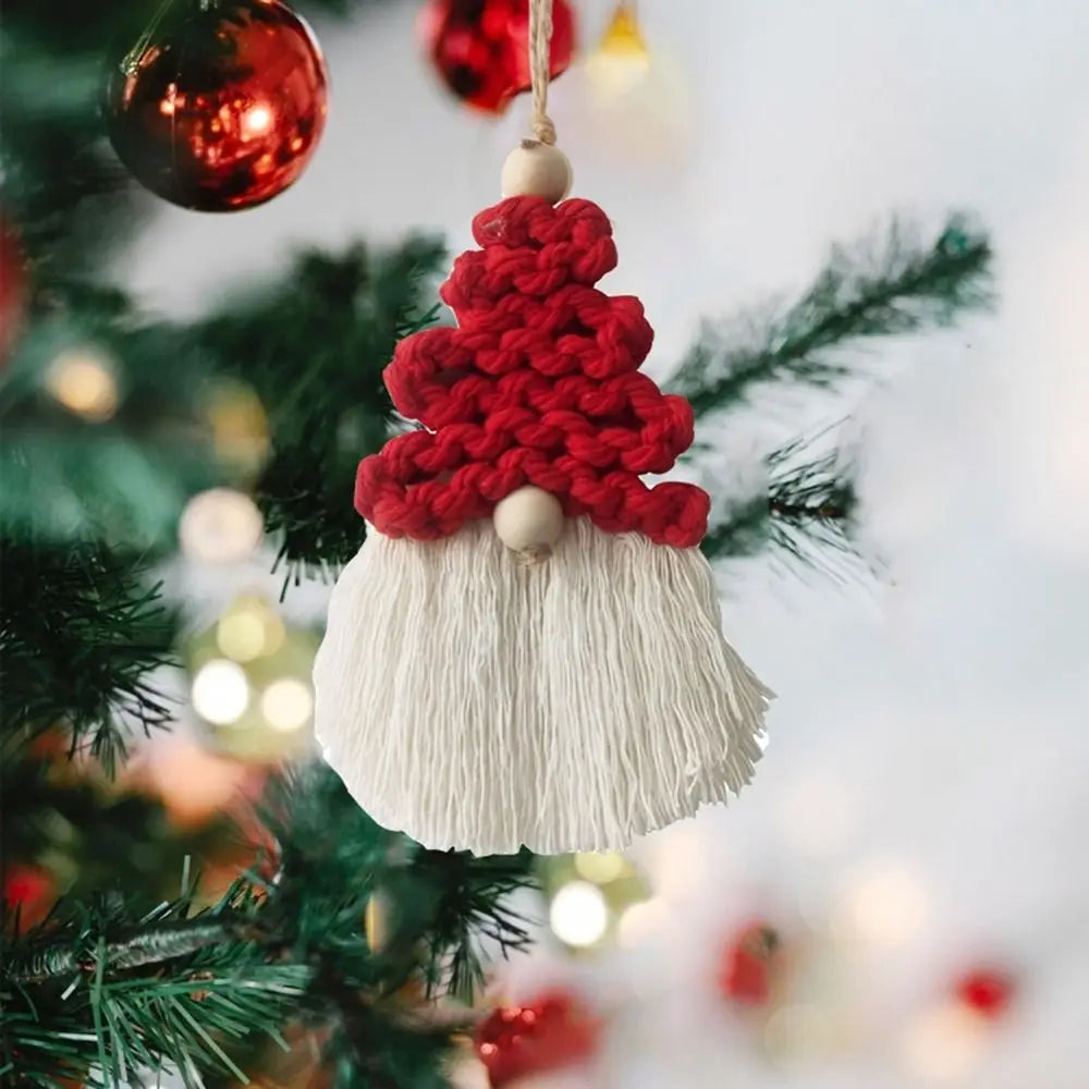 Decorative gnome macrame ornament with red top and white beard hanging on a Christmas tree.