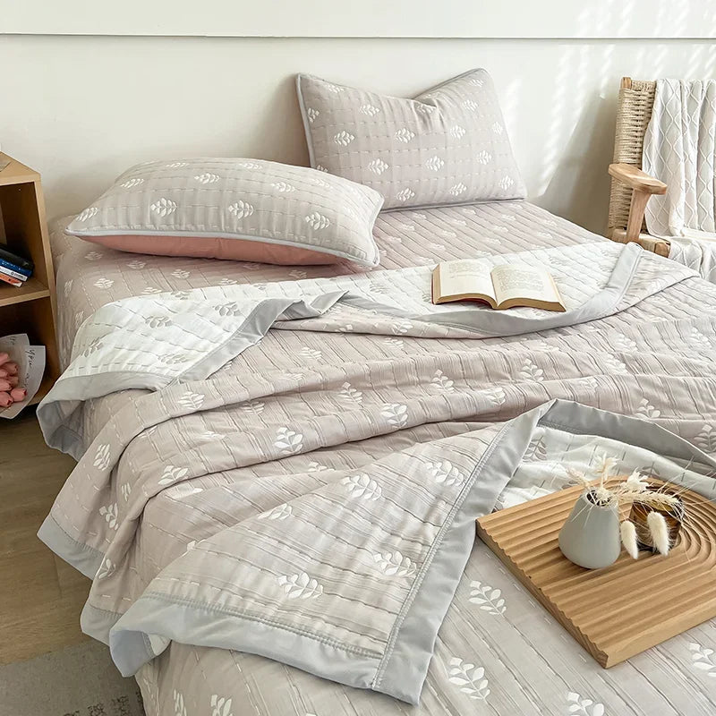 Neatly made bed with floral-patterned bedding in a bedroom setting. Boho breathable lightweight summer spring fall blanket quilt bedspread 