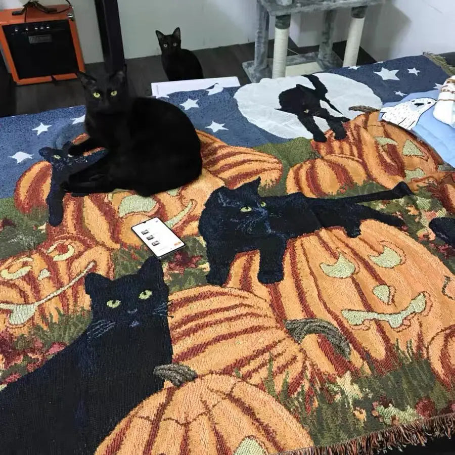 Black cats on a Halloween-themed rug with pumpkins and ghosts. Cozy Halloween blanket with pumpkins and cats, boho woven couch cover for fall home decor