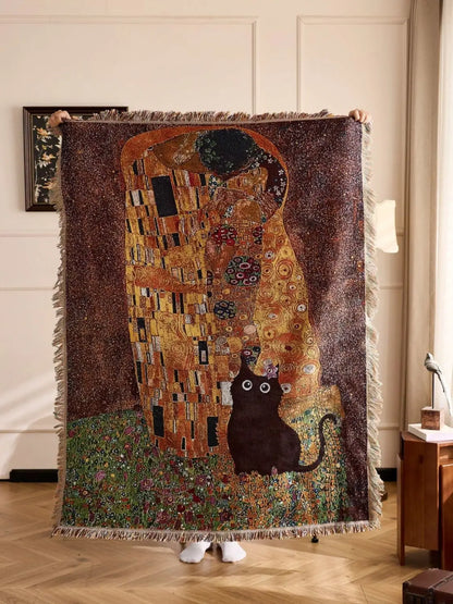 Blanket with 'The Kiss' design by Gustav Klimt featuring a cat, held up indoors. Cat woven throw blanket for boho sofa and home decor