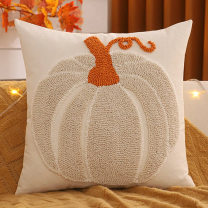 Decorative pillow with a pumpkin design on a couch with autumn leaves in the background. Tufted Halloween pumpkin pillow cover autumn decorative cushion