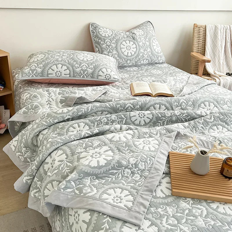 Bed with gray floral bedding in a bedroom setting. Boho breathable lightweight summer spring fall blanket quilt bedspread 