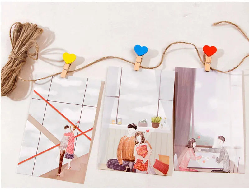 String with heart-shaped clips holding photos of a couple on a white background