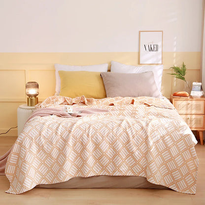 Bedroom with a bed featuring a patterned comforter, pillows, and nightstands. Boho Lightweight microfiber summer blanket for bed or sofa, cooling breathable throw for home, dorm, or office naps with geometric jacquard pattern.
