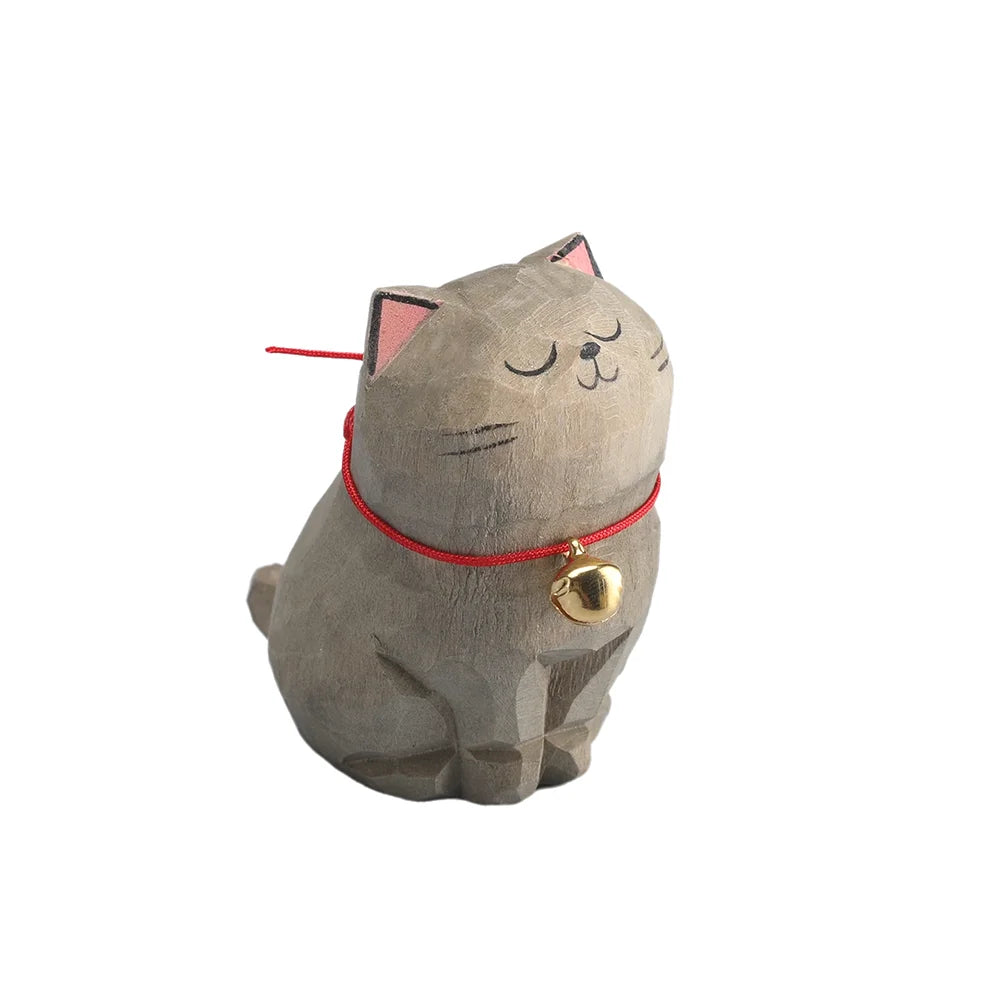 Cat-shaped decorative item with a red collar and gold bell on a white background