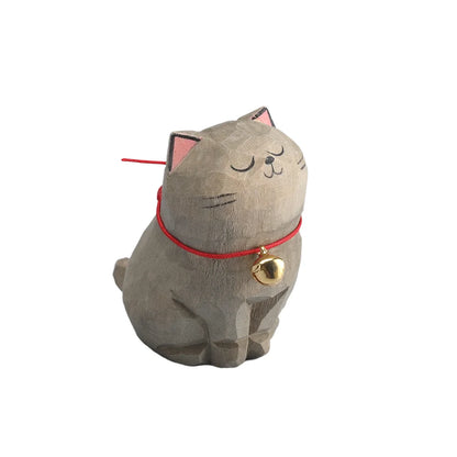 Cat-shaped decorative item with a red collar and gold bell on a white background