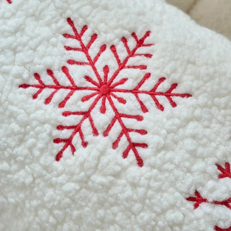 Red snowflake embroidery on a textured white fabric background