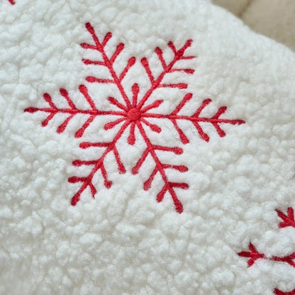 Red snowflake embroidery on a textured white fabric background