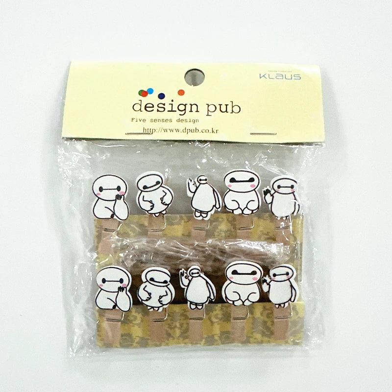 Packaged wooden clips with cartoon character designs on a white background, branded 'Klaus' and 'Design Pub'.