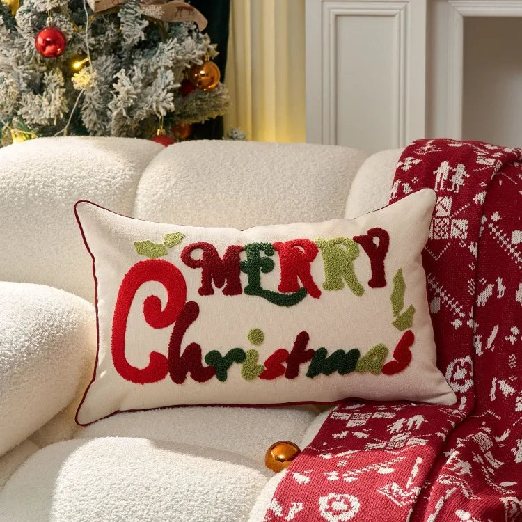 Decorative pillow with 'Merry Christmas' text on a couch with a Christmas tree in the background