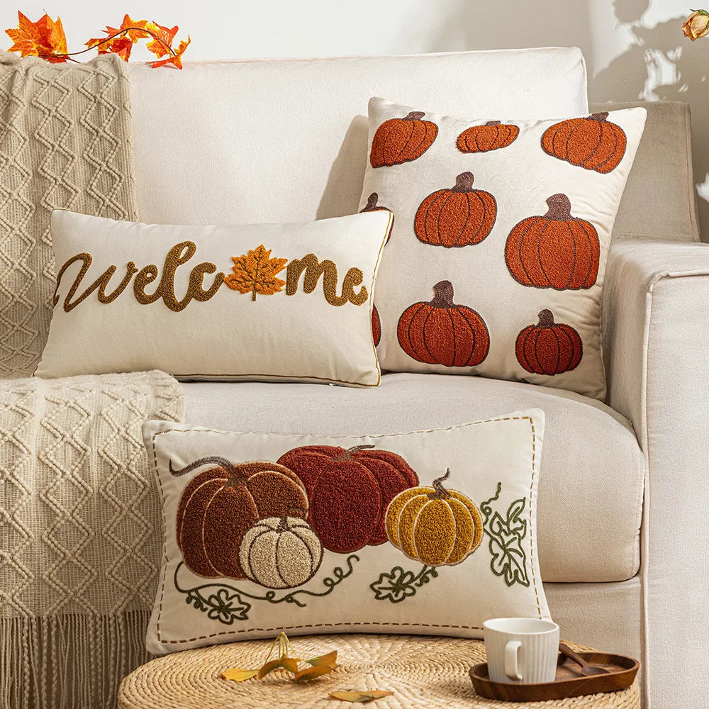Decorative pillows with pumpkin patterns on a beige sofa with autumn leaves. Autumn velvet embroidered pumpkin pillow cover, Nordic-style decorative cushion for sofa, bed, and fall boho home decor